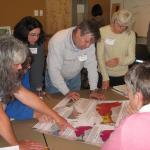 Action team works together on a community hazard inventory activity using maps of relative earthquake hazard (landslides, liquefaction, and amplification) and tsunami inundation.